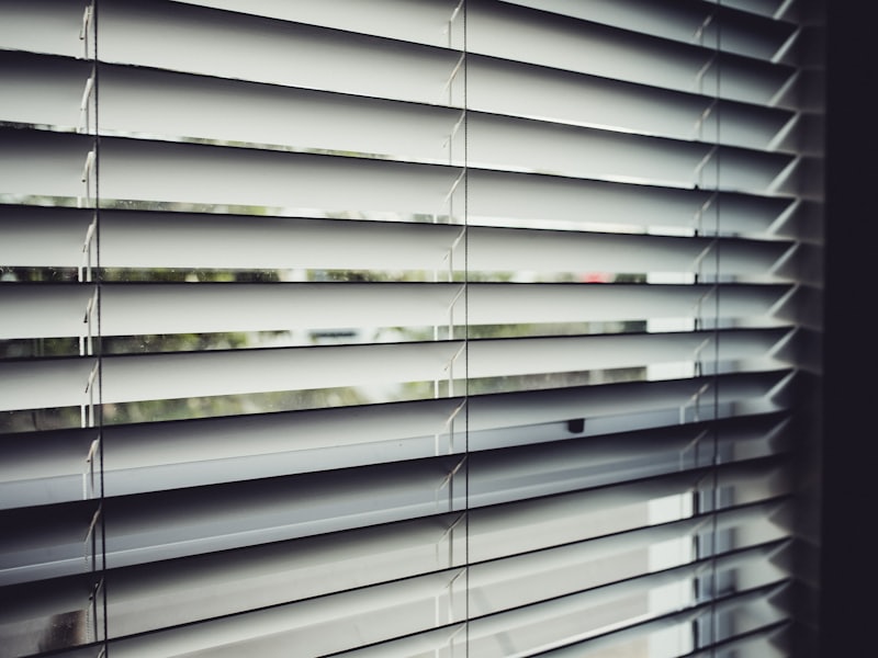 Close view of white faux wood blinds with the slats tilted open